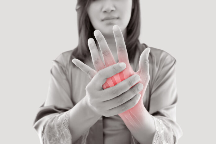 Woman with hand pain Asian woman suffering from pain in bone against gray