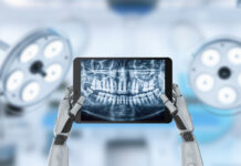 Miniatuurrobot kan restauratieve tandheelkunde ingrijpend veranderen Robothand met digitale tandarts scan op scherm in kliniek.